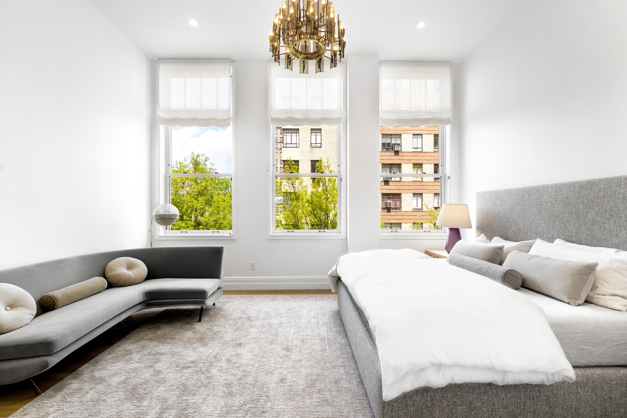 Bedroom with tall windows and brass chandelier