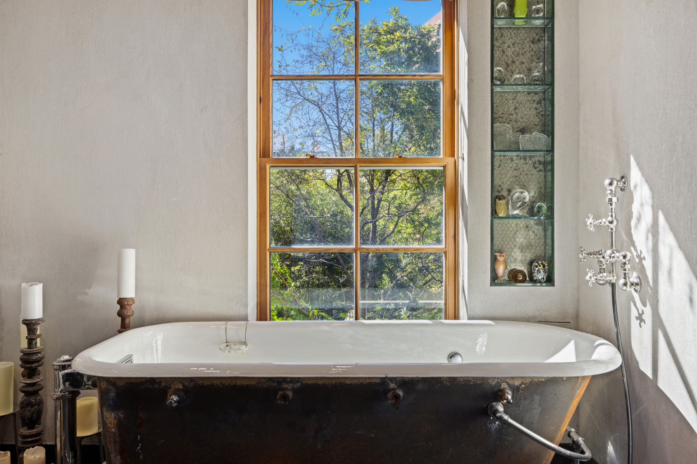 Antique bathtub beneath a tall garden window
